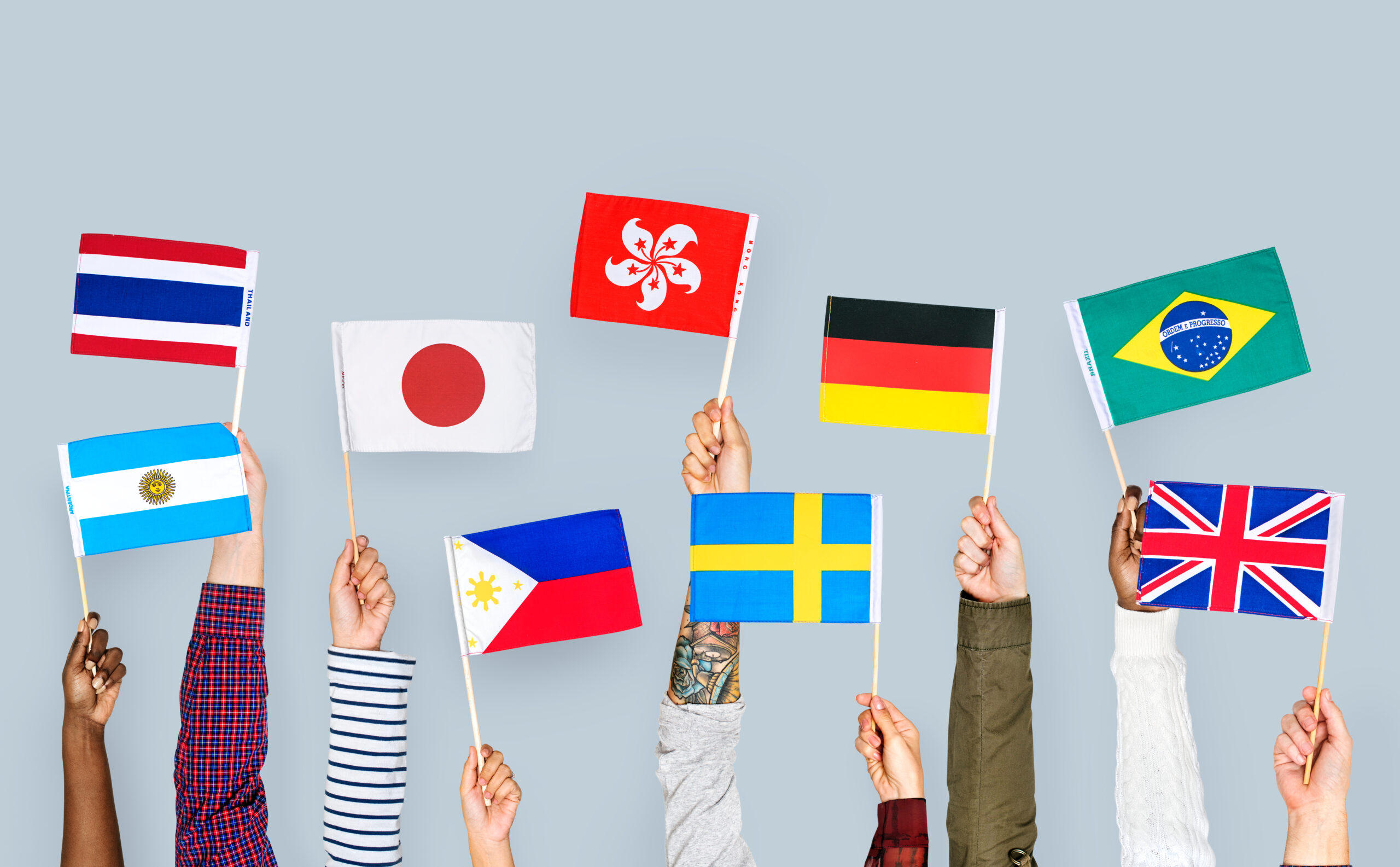 さまざまな国の国旗を掲げる人々のイメージ写真